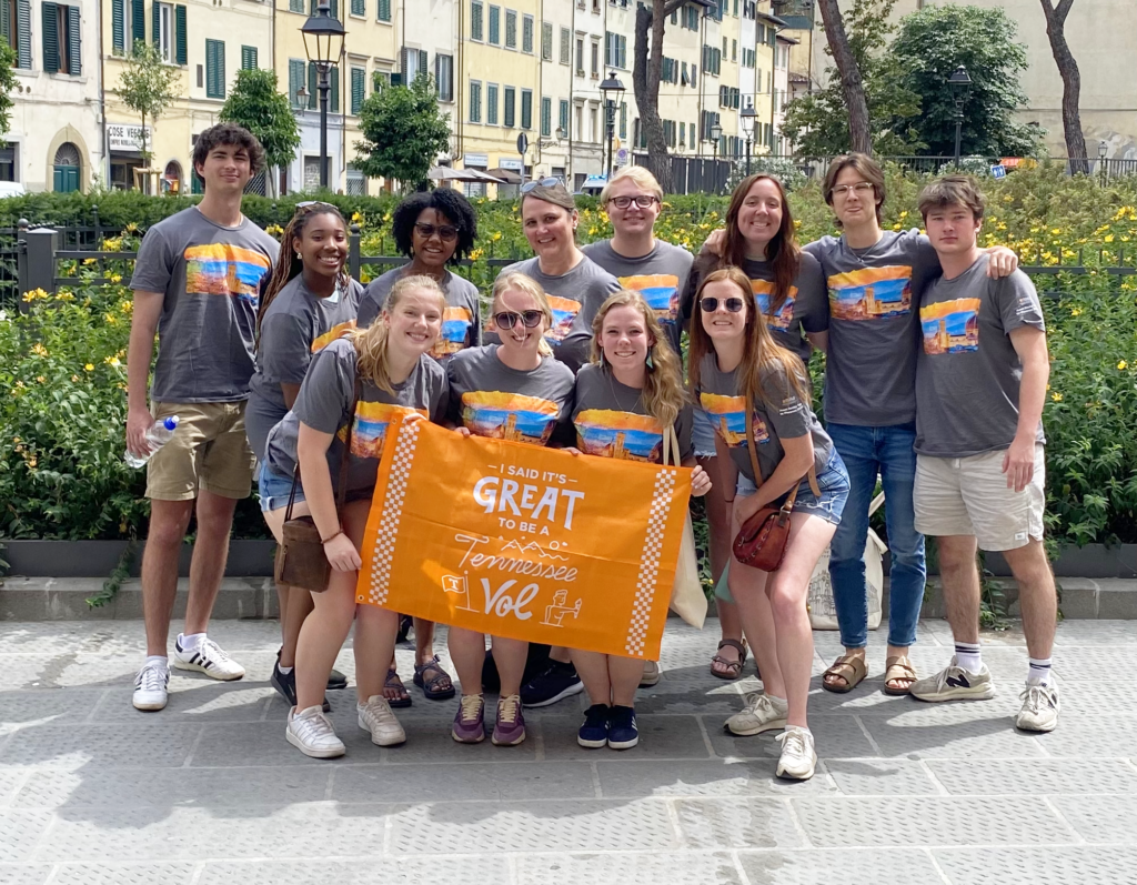 ISE study abroad students pose with Vol flag in Italy.
